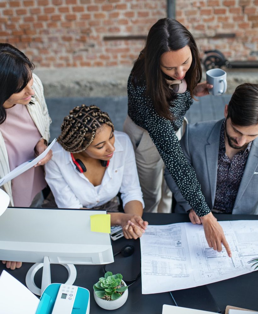 top-view-of-young-and-old-architects-sitting-and-working-at-desk-in-office-cooperation-concept.jpg